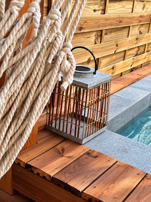 A wooden deck with a metal lantern and ropes.