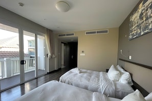 A hotel room with two beds, a balcony, and a view of the outside. - Elegant Pool Villa My Khe Beach Danang (Da Nang Municipality)