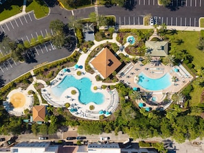 An aerial view of a resort with multiple swimming pools, a large central pool, and a parking area. - Perfect Orlando Stay, Comfort at Prime Location (Orlando)