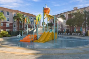 A water park with slides and a splash pad, surrounded by buildings. - Perfect Orlando Stay, Comfort at Prime Location (Orlando)