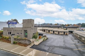 A motel with a signboard, a parking lot, and multiple buildings. - Selkirk Motel  (Colville)