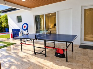 A ping pong table set up outdoors with a target and paddles nearby. - The Quiet Luxury (Hollywood)