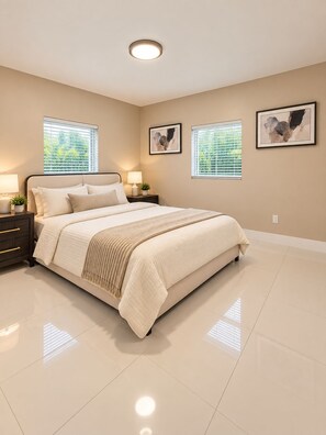 A bedroom with a bed, nightstands, lamps, and artwork on the walls. - The Quiet Luxury (Hollywood)