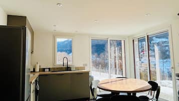 Una cocina moderna con comedor, ventanas amplias y vistas al exterior.