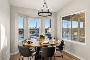 A dining area with a round table, black chairs, and a chandelier. - Arizona Luxury Home. 5 Mins from Stadium. Play-Structure, Pool, Basketball Court (Peoria)
