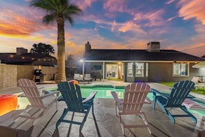 A backyard with a swimming pool, lounge chairs, and a patio area. - Arizona Luxury Home. 5 Mins from Stadium. Play-Structure, Pool, Basketball Court (Peoria)