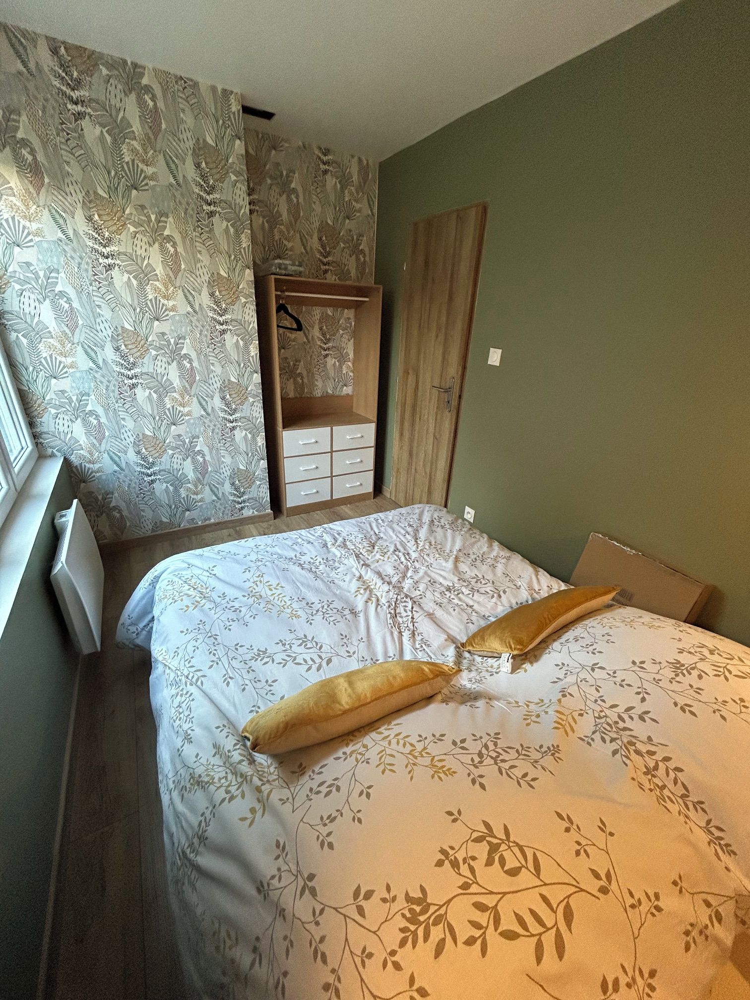 Een slaapkamer met een bed, een kledingkast en een zwevende garderobe.