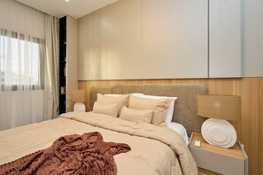 A hotel room with a bed, bedside lamps, a bedside table with a phone, and a window with curtains. - Premium one-bedroom apartment in Fann-Mermoz · Corniche within walking distance (Dakar)