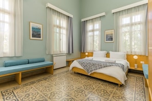 A bedroom with a bed, a bench, two bedside tables, and a radiator. - Breathe Batroun by Stayinn (Batroun)