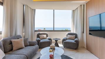 A modern living room with grey sofas, a coffee table, and a TV mounted on the wall.