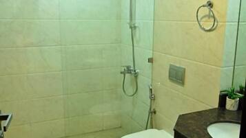 Un baño con cabina de ducha de vidrio, inodoro y lavabo con espejo.