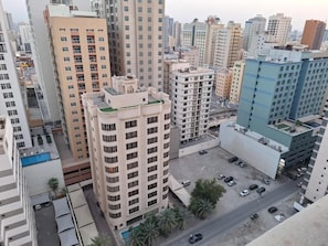 A high-rise building with multiple floors, a parking area, and surrounding urban buildings. - Aspire Tower (Manama)