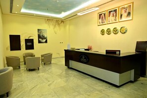 A reception area with a marble floor, a reception desk, and several chairs. - Aspire Tower (Manama)