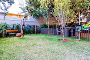 A grassy yard with a bench, a tree, and a metal fence. - New Listing (São Paulo)