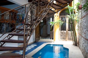 Uma área de piscina com escada de metal e piso cerâmico.