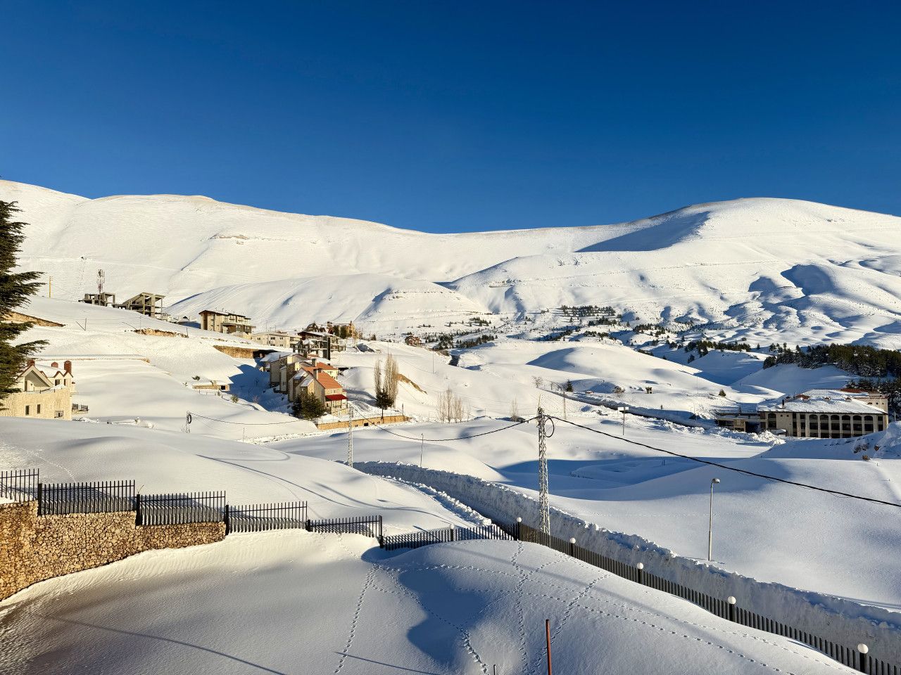 A snow-covered landscape with buildings and a clear sky.