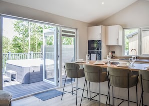 A modern kitchen with a dining area, a hot tub, and a sliding glass door leading to a deck. - 1 bedroom accommodation in Doncaster, South Yorkshire (Doncaster, South Yorkshire)