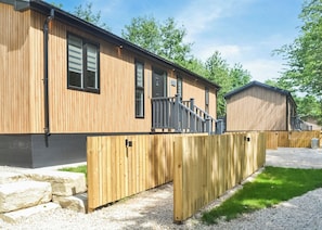 A wooden building with a covered porch and a fenced area. - 1 bedroom accommodation in Doncaster, South Yorkshire (Doncaster, South Yorkshire)