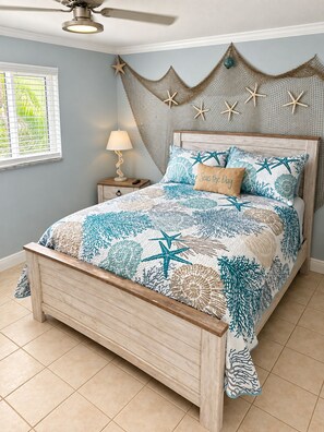 A bedroom with a bed, a nightstand, a lamp, a ceiling fan, and a window with blinds. - Cozy 1BR Beach Retreat. Just Blocks from Clearwater Beach (Clearwater)