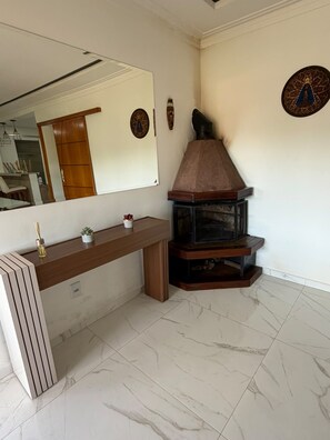 A bathroom with a vanity, mirror, and a wood-burning stove. - New Listing (Batatuba)