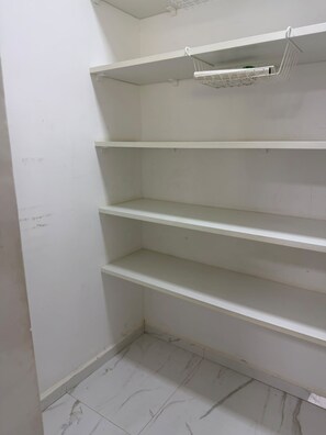 A white interior with four shelves and a hanging rack. - New Listing (Batatuba)