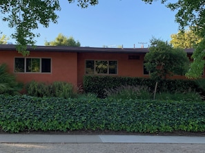A red building with two windows and a hedge in front. - Modern Kitchen 3BR Home w/ Yard (San Luis Obispo)