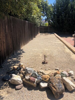 A gravel path with a wooden fence on one side and a brick wall on the other. - Modern Kitchen 3BR Home w/ Yard (San Luis Obispo)