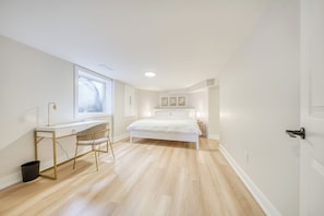 Een slaapkamer met een bed, een bureau en een stoel.