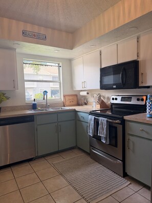 A kitchen with a built-in microwave, oven, and dishwasher. - Welcome to the Sandy Beach Oasis, your relaxing New Smyrna Beach getaway! (New Smyrna Beach)