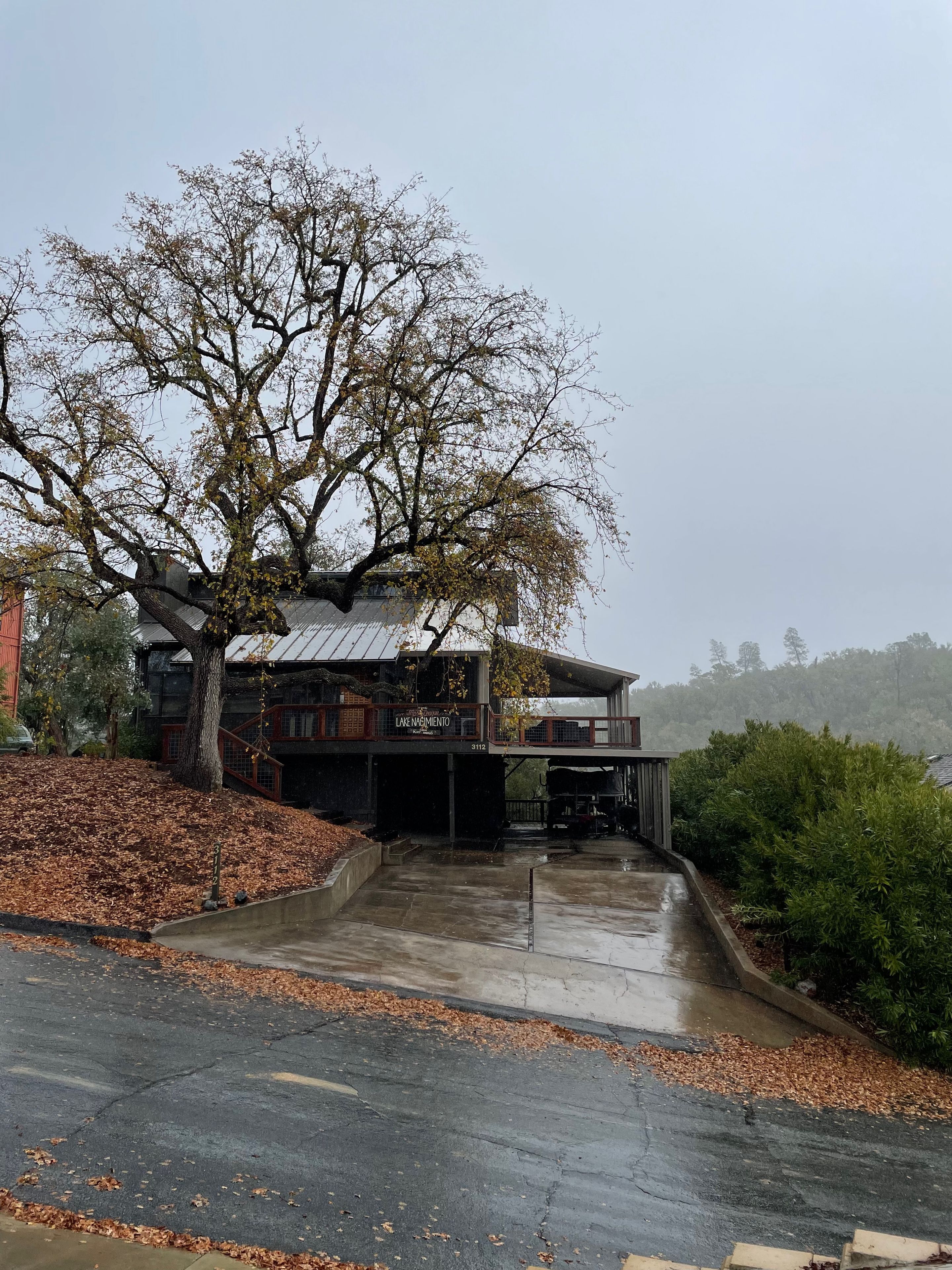 Un bâtiment à deux étages, doté d’une entrée couverte et d’un grand arbre à l’avant.