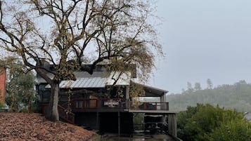 Un bâtiment à deux étages, doté d’une entrée couverte et d’un grand arbre à l’avant.