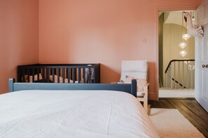 A bedroom with a bed, a chair, and a staircase leading to a door. - Beautiful Georgian Farmhouse Country Escape (Gloucester)