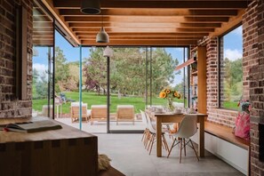 A modern interior with a dining area, large windows, and a view of the outdoors. - Beautiful Georgian Farmhouse Country Escape (Gloucester)