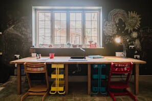 A room with a large window, a desk with a lamp, and two chairs. - Beautiful Georgian Farmhouse Country Escape (Gloucester)