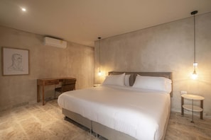 A bedroom with a large bed, a desk, and two bedside tables. - 11 Bedroom Luxury Villa in Old City (Cartagena de Indias)
