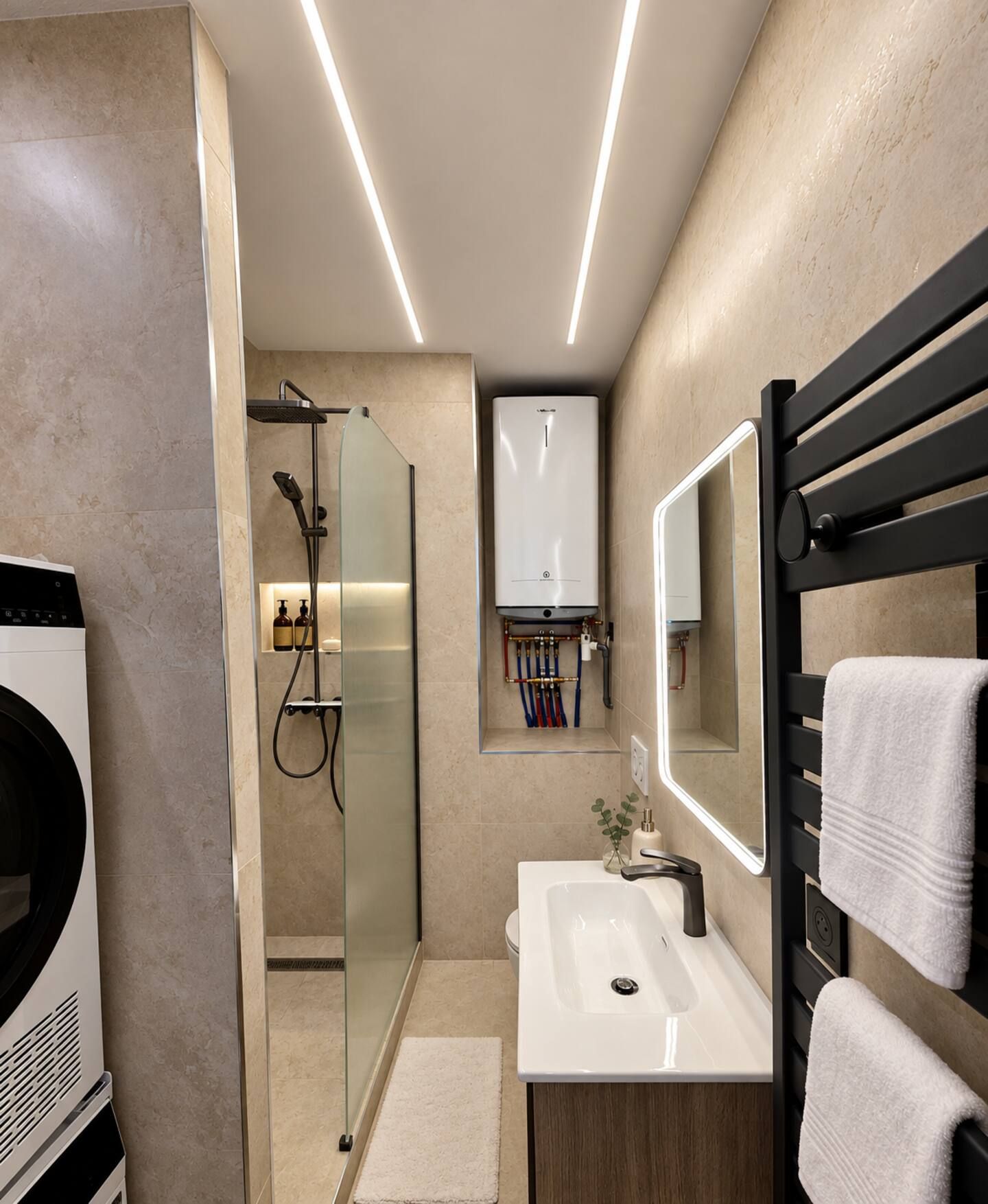 Une salle de bain moderne avec une douche à parois de verre, un lavabo blanc et un porte-serviettes noir.