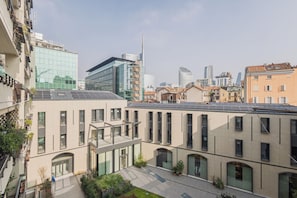 Ein modernes Gebäude mit Glasfassade, einem Dachgarten und Blick auf die Skyline der Stadt.