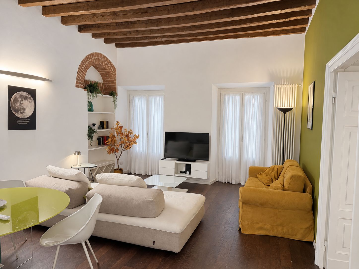 A modern living room with a sofa, a yellow armchair, a TV, and a dining area with a table and chairs.