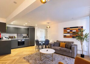 A modern apartment with a kitchen, dining area, and living room. - Luxury City Centre Apartment with Canal View (West Midlands)
