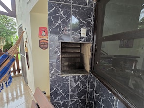 A room with a marble wall, a hammock, and a small shelf.