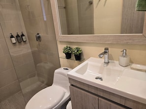 Een badkamer met toilet, wastafel en douche.