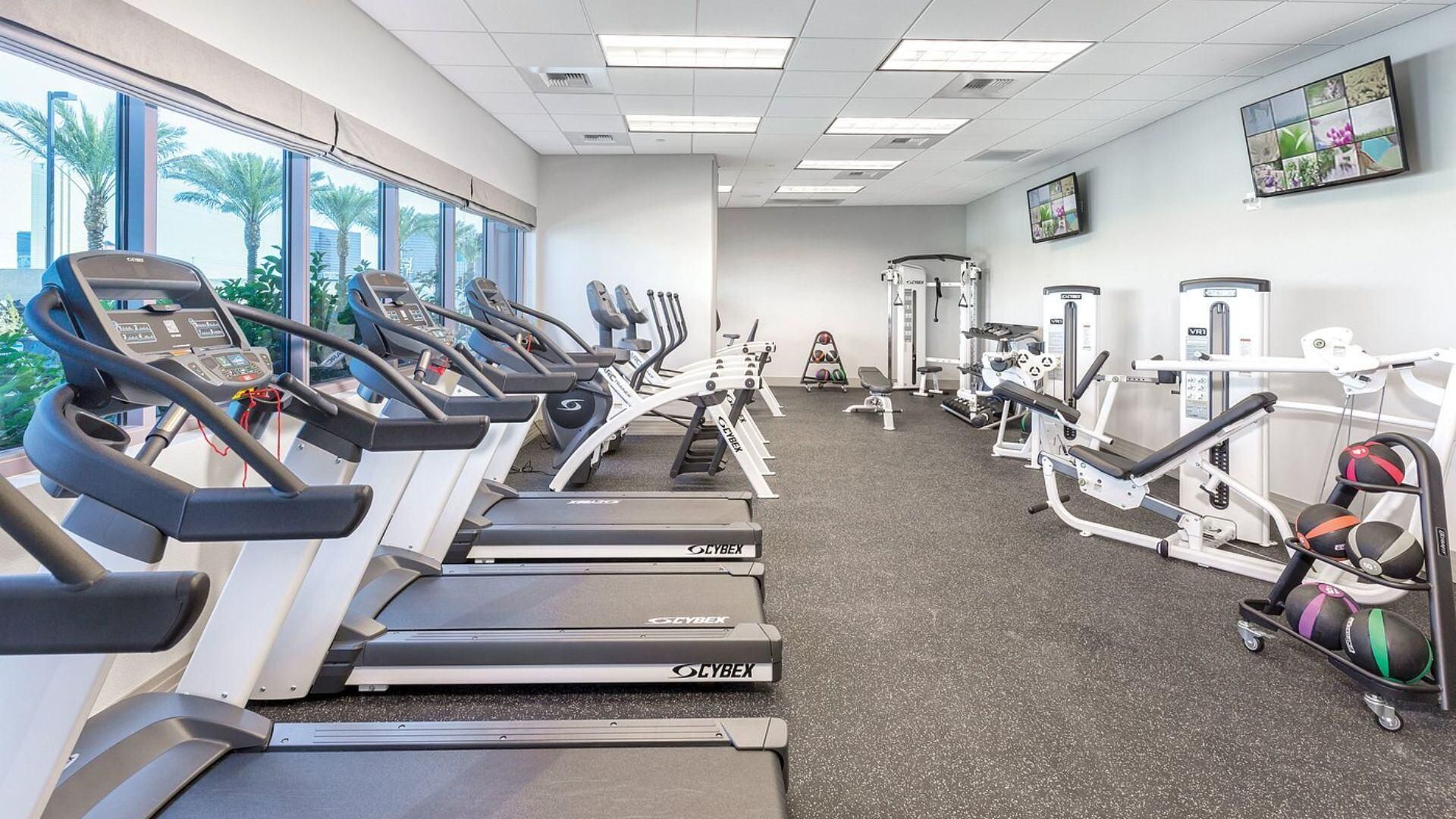 A gym with treadmills, weight machines, and exercise balls.