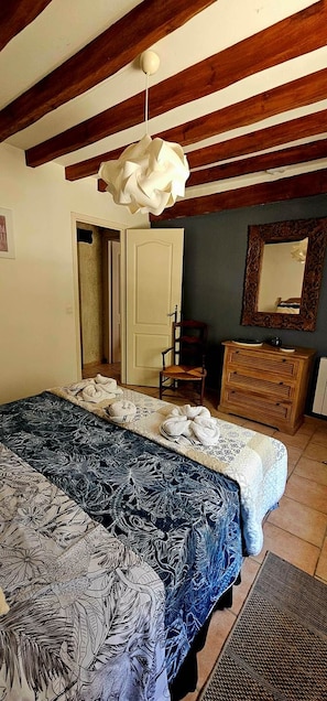 Ein Schlafzimmer mit einem Bett, einem Holzschrank und einem Spiegel.