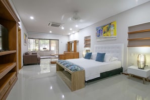 Un dormitorio moderno con una cama grande, un sofá, un escritorio y una ventana.