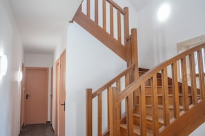 Eine Holztreppe mit Handlauf, die zu einer oberen Etage führt.