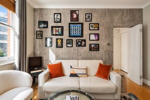 A living room with a sofa, a coffee table, and framed pictures on the wall. - Music-Lover's Flat Vinyl Icons Spitalfields (Greater London)