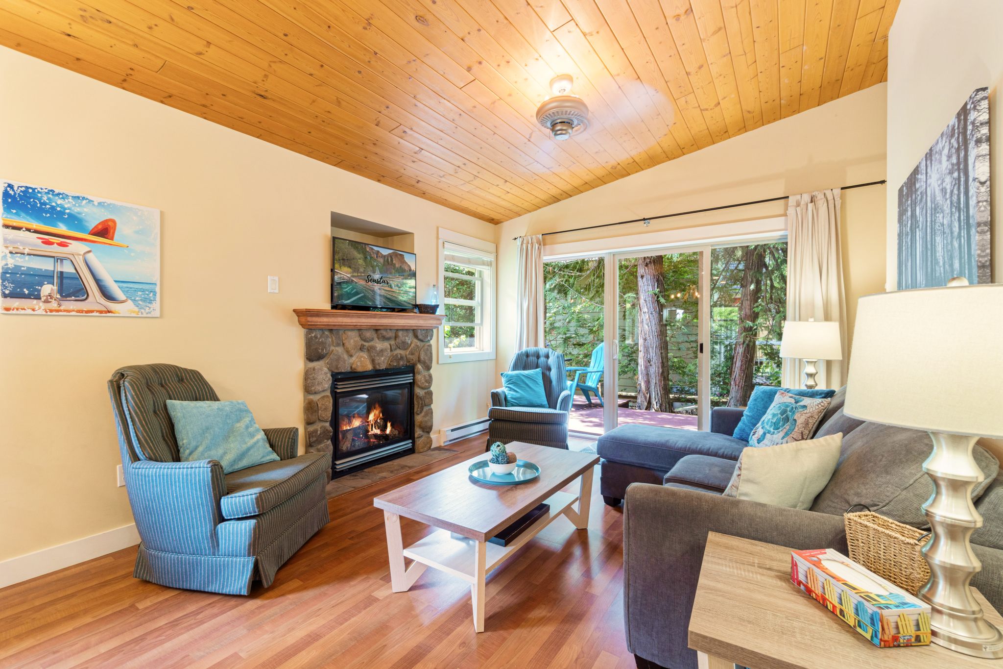 Una sala de estar acogedora con chimenea, asientos cómodos y ventanas amplias con vistas al exterior.