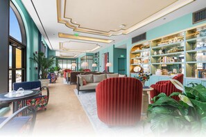 A hotel lobby with seating areas, a reception desk, and a large bookshelf filled with decorative items. - NoMad Residences Wynwood Private Luxury Suites (Miami)