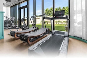 A gym with treadmills, stationary bikes, and exercise equipment. - NoMad Residences Wynwood Private Luxury Suites (Miami)