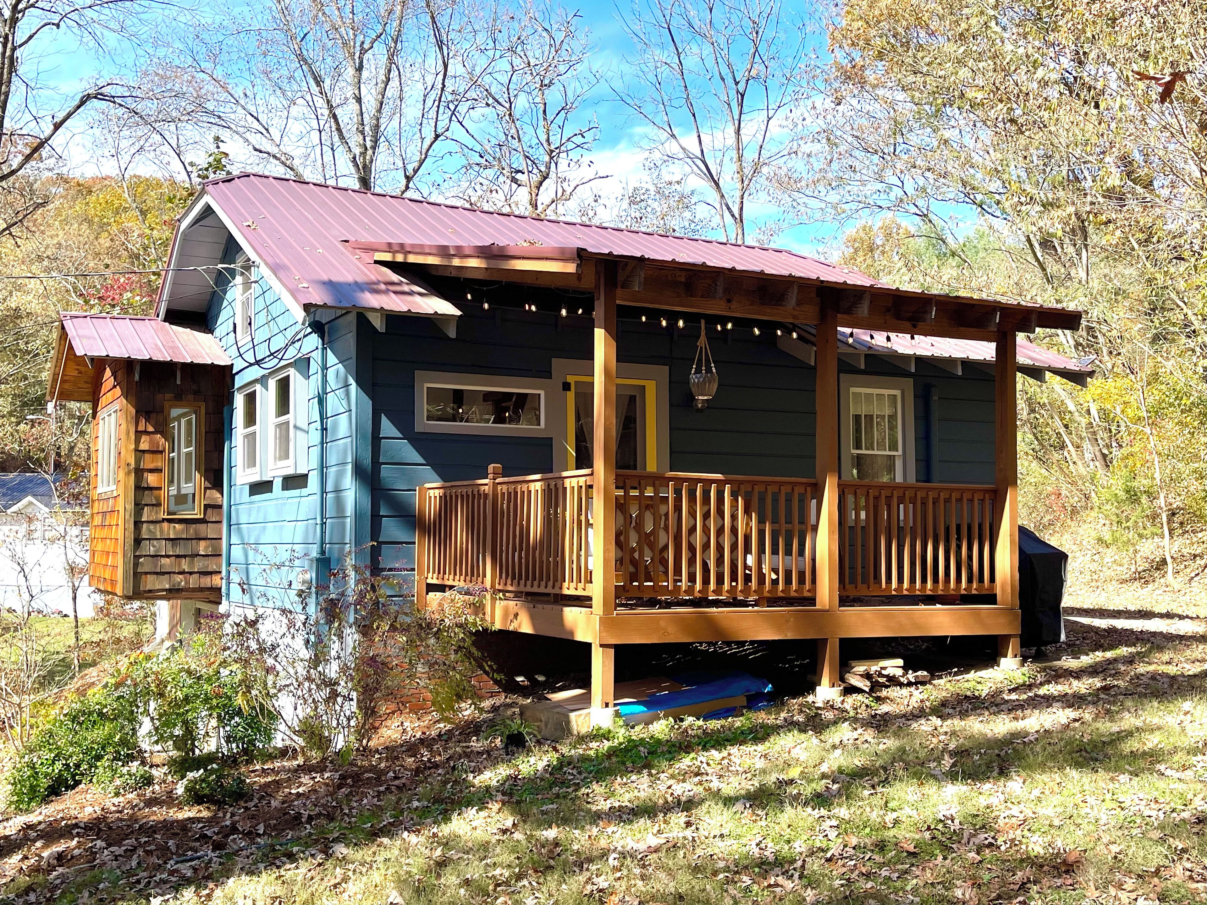 A cabin with a wooden deck and a metal roof.